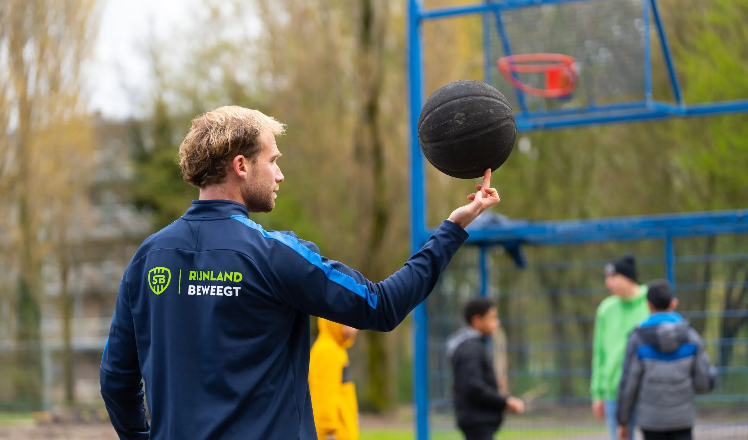Buurtsportcoach op basketbalveld