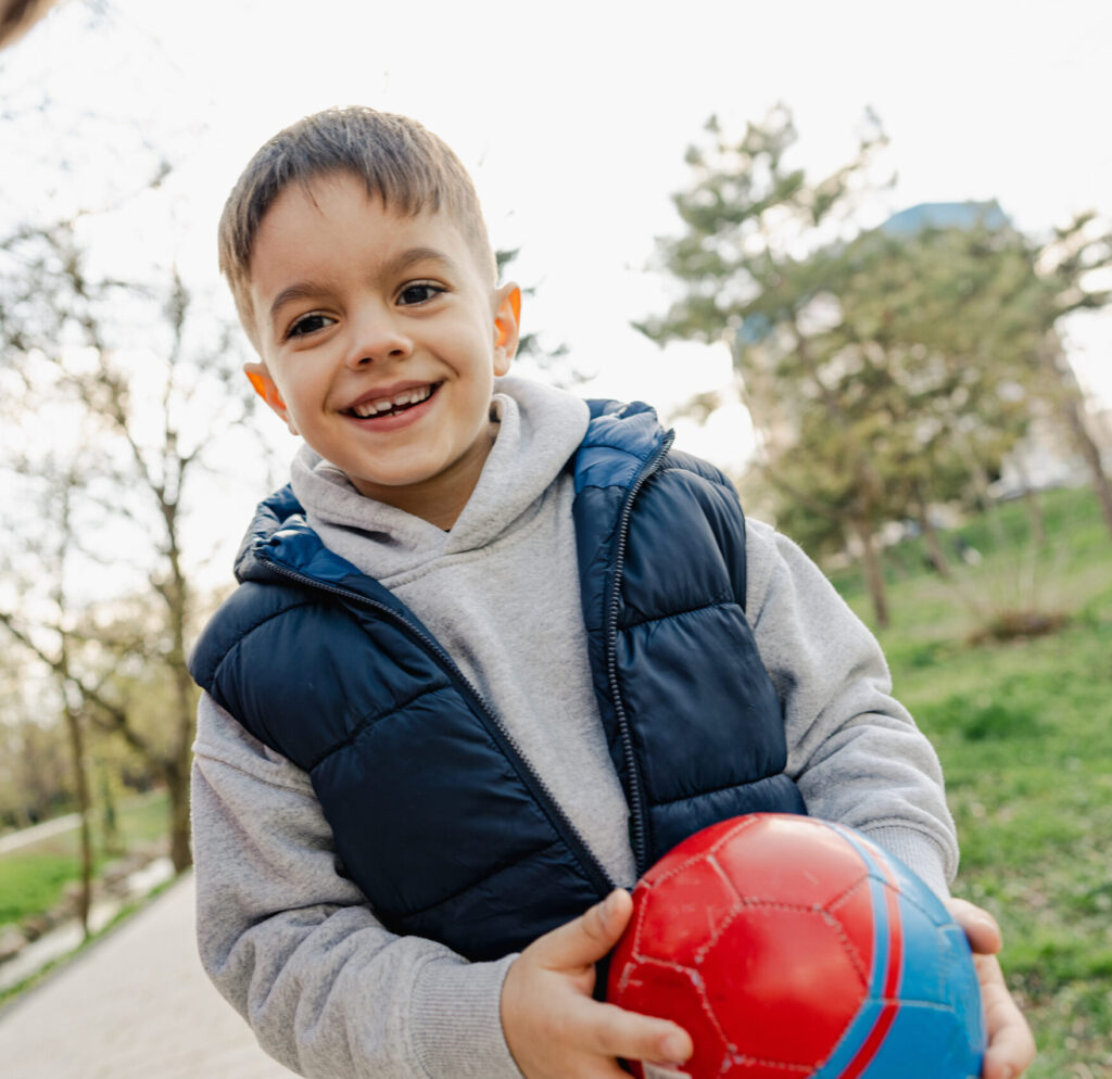 Jongen loopt buiten met bal