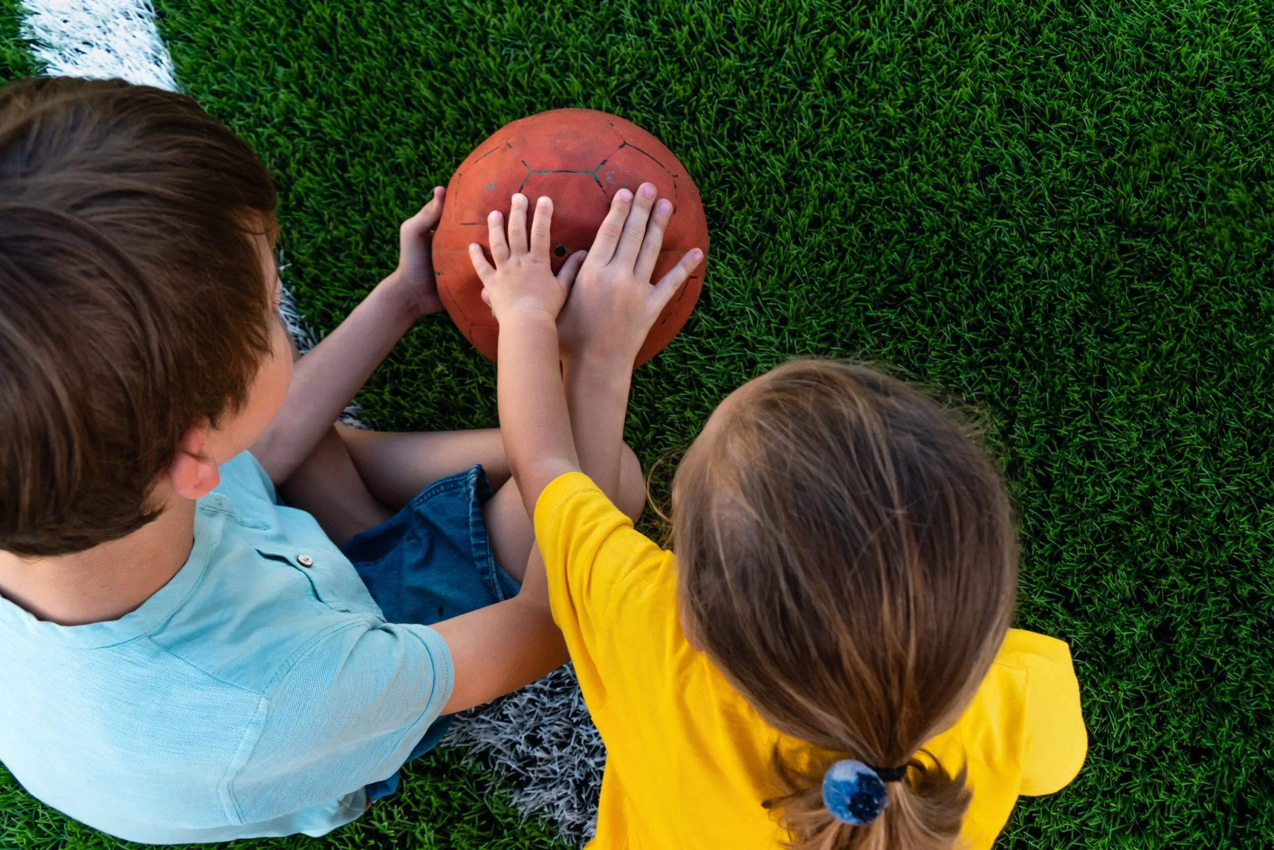 Jongen en meisje die samen met de bal spelen